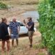 People in vineyard discussing wine